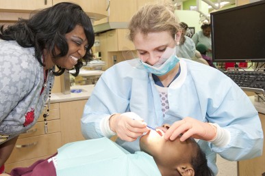 Agata Lefere gives 8th grader Serina Hughes a dental exam