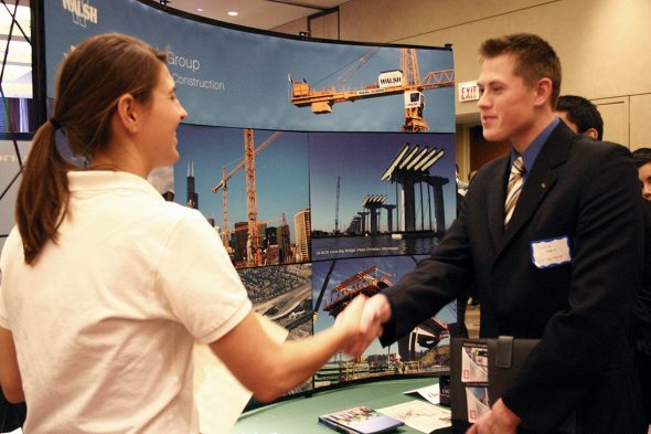 An engineering student networks at job fair
