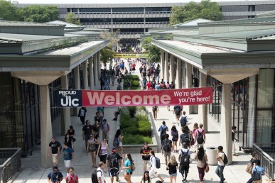 students walking on campus under a welcome banner