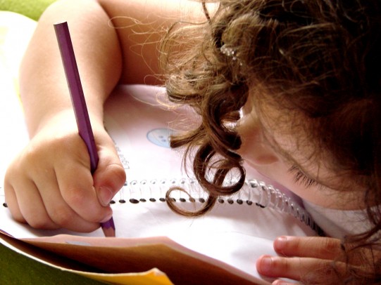 young girl drawing in a workbook