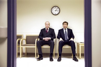Michael Caine and Nicholas Cage sitting in a waiting room