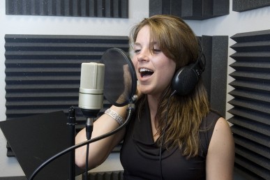 young woman singing at a recording studio