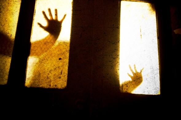Silhouette of hands through a window