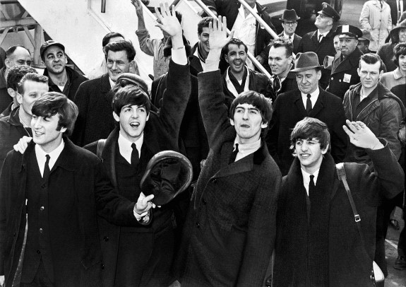 Beatles wave to fans after arriving at Kennedy Airport, Feb. 7, 1964