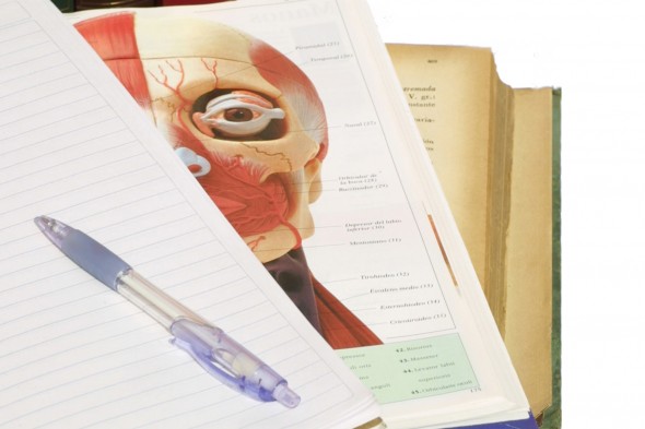 notebook and pen on top of anatomy textbook