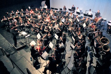 Aerial view of symphonic band and conductor performing
