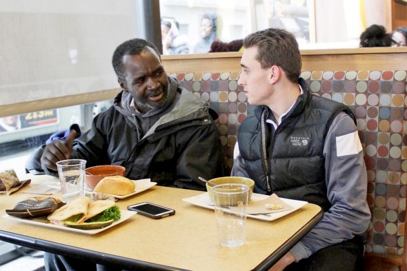 SPARK volunteer sits with homeless man in restaurant