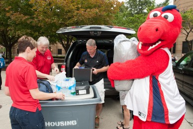 Freshman Daniel Stewart gets a hand from the Amiridis', Susan Teggets, Director of Campus Housing and Sparky.