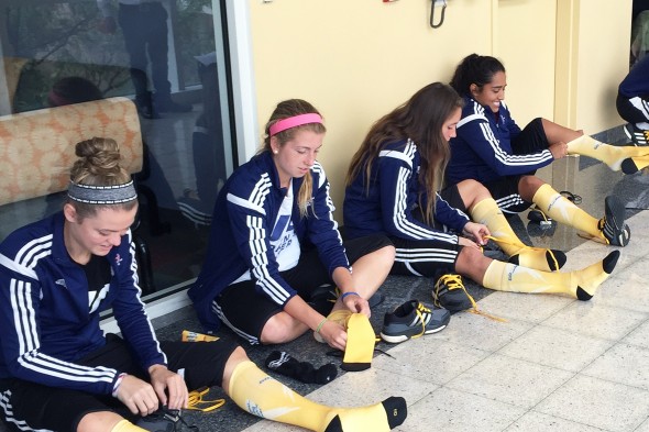 Women's soccer team putting on gold socks