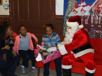 Officer Santa Braulio DeAnda hands out gifts at the UIC Police Station Friday. 