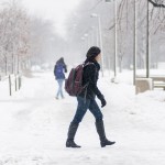 Girl walks through the snow on campus