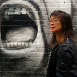 Lisa Lee in front of a graffiti face