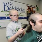 Boy shaving Alberto Locante's head for St. Baldrick's.