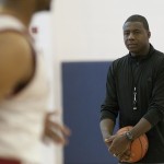 Howard Moore holds a basketball while watching his team practice