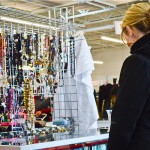 Girl looks at thrift store jewelry selection