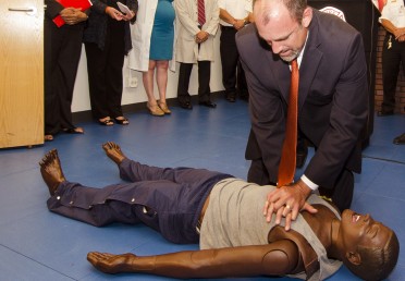 Man practices CPR on a dummy;