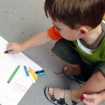 Young boy drawing with crayons
