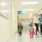 Children walk down hospital hallway in Halloween costumes