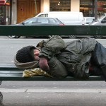 Homeless person sleeping on a bench
