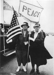 Jane Addams (right) with an American flag and banner reading "Peace"