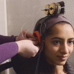 Researcher affixing a device to a participant's ear