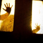 Silhouette of hands through a window
