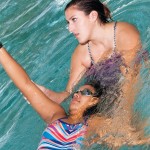 Young woman learning to swim with instructor