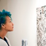 woman looking at a painting in "Here, There, Everywhere"