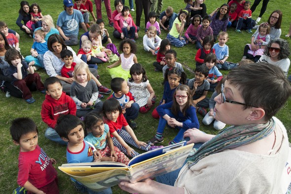 Woman reads book to a group of children