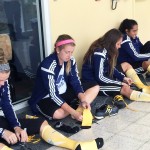 Women's soccer team putting on gold socks