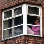 girl sitting in window looking down