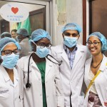 Group of doctors or medical students in lab coats wearing masks and hairnets