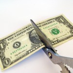 scissors cutting a dollar bill