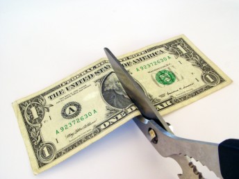 scissors cutting a dollar bill