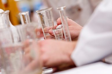 view of hands among chemistry glassware