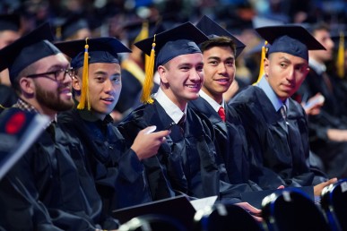 graduates seated, smiling