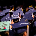 view of graduates' hats, one reading "thanks mom and dad"