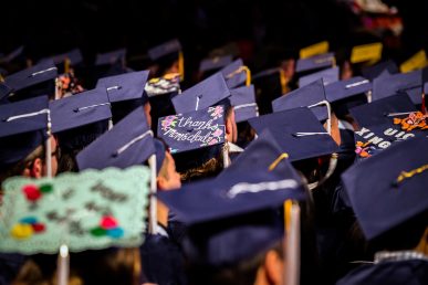 view of graduates' hats, one reading "thanks mom and dad"