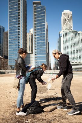 students cleaning up trash on a beach