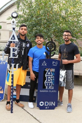 Fraternity members with sign and Greek letters