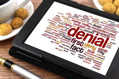 tablet with word cloud relating to "denial"