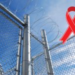 barbed wire fence with a red ribbon representing HIV/AIDS awareness