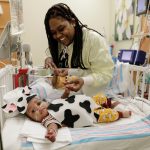 Tiayanna James smiles at her son I'mari in his cow costume during the UI Health pediatrics Halloween party Thursday, October 31, 2019, at University of Illinois Hospital. The NICU dressed all the babies in barnyard themed costumes this year.
