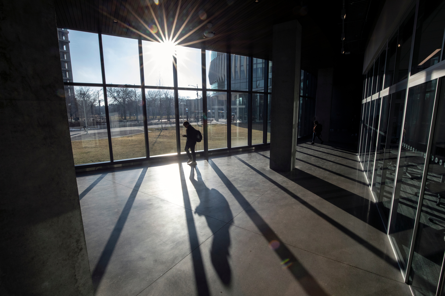 A student walks through the Academic and Residential Complex as the sun peaks through the clouds Tuesday evening.