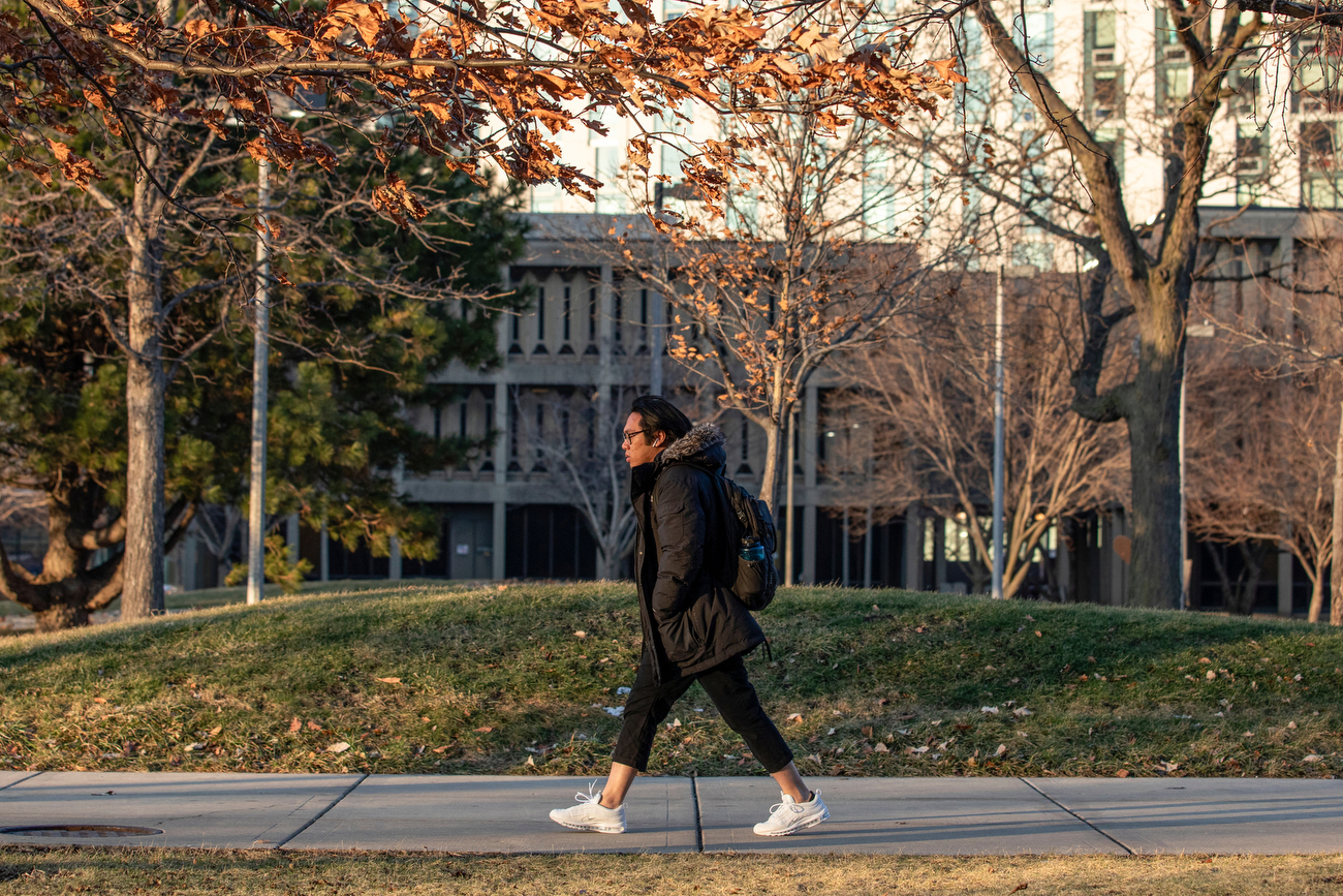 A student walks briskly into the wind outside Stevenson Hall as the sun sets on another day.