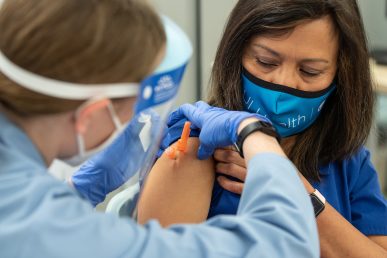 Nurse Enriqueta “Ket” Gomez receives the Pfizer COVID-19 vaccine