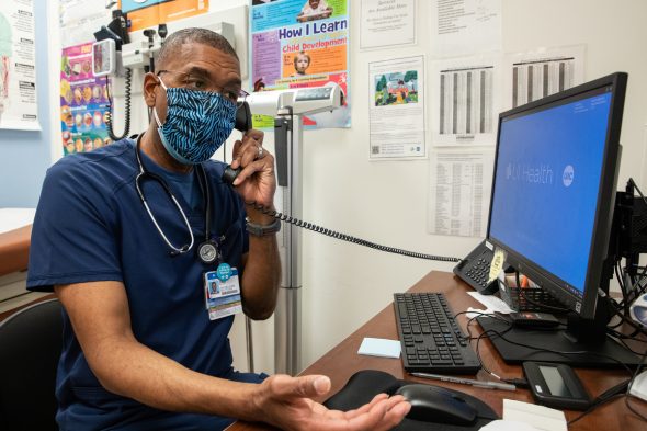 Dale Benton, certified nurse practitioner and site medical director, makes a call between seeing patients and encouraging people to get vaccinated at UI Health Mile Square Health Center in Englewood.