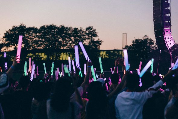 Crowd of concertgoers with light sticks.
