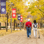Students walking on campus viewing fall foliage