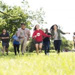 A group of students running through a field